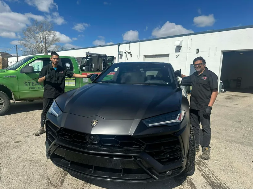 Completion of a windshield crack repair on a Lamborghini Urus by two expert technicians at Stealth