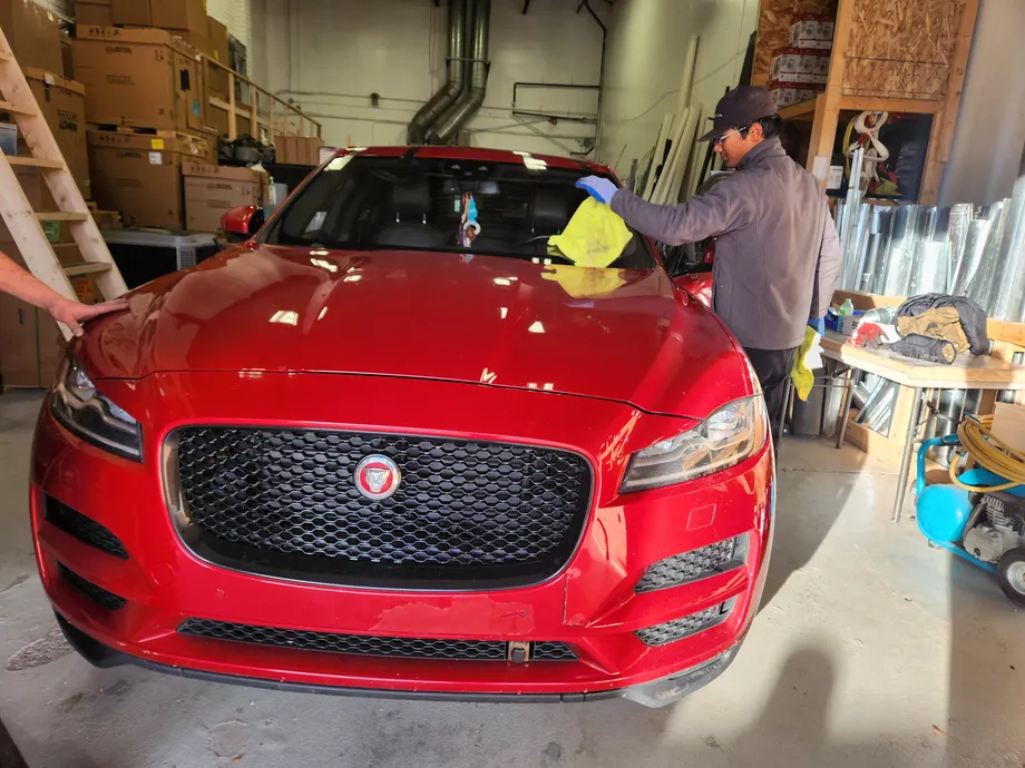 A red Jaguar F-PACE after windshield chip repair at our Stealth Windshield Repair garage