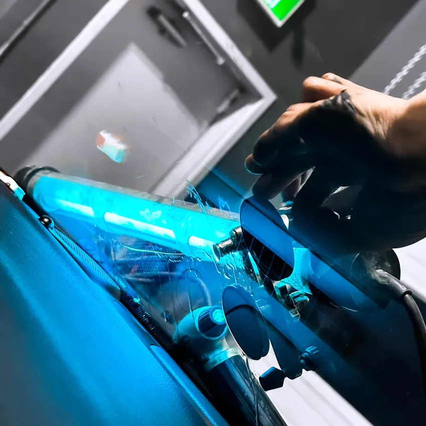Curing Resin using UV light during a windshield crack repair service.