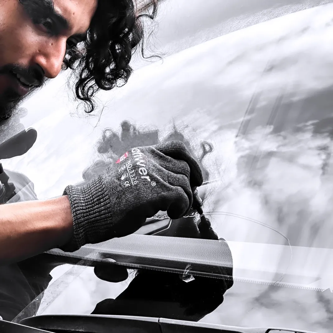 Car windhsield reflects a cloudy, grey sky during a windshield chip repair job at Stealth Windshield Repair