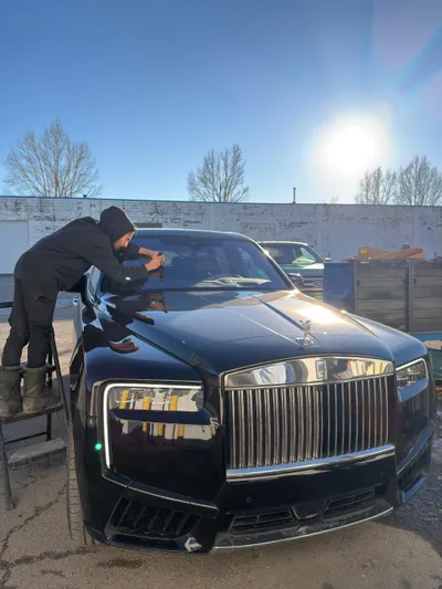 Fixing a windshield chip on a Rolls-Royce Cullinan at a Stealth Windshield Repair tent